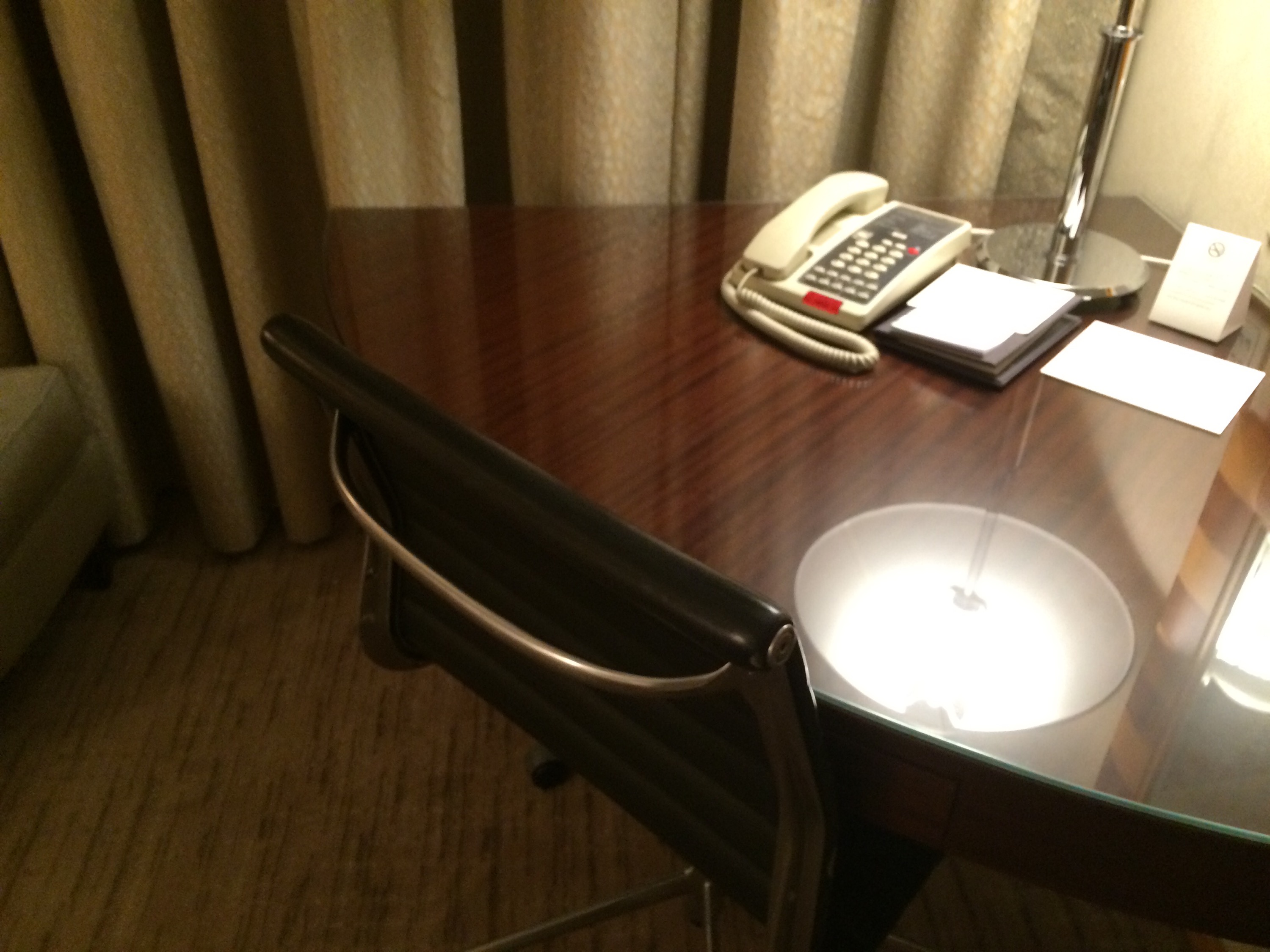 a desk with a telephone and a lamp