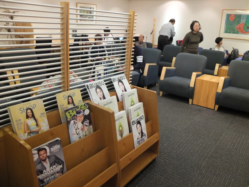 a group of people in a room with chairs and magazines