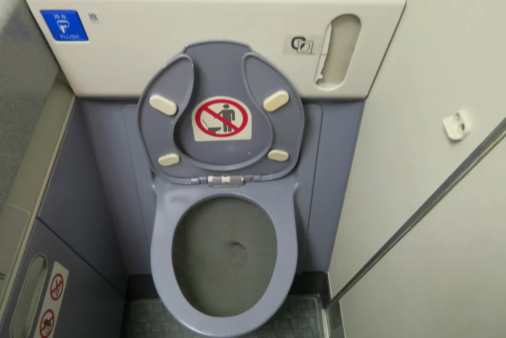 a toilet with a no smoking sign