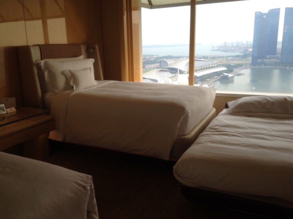 a room with two beds and a view of the city