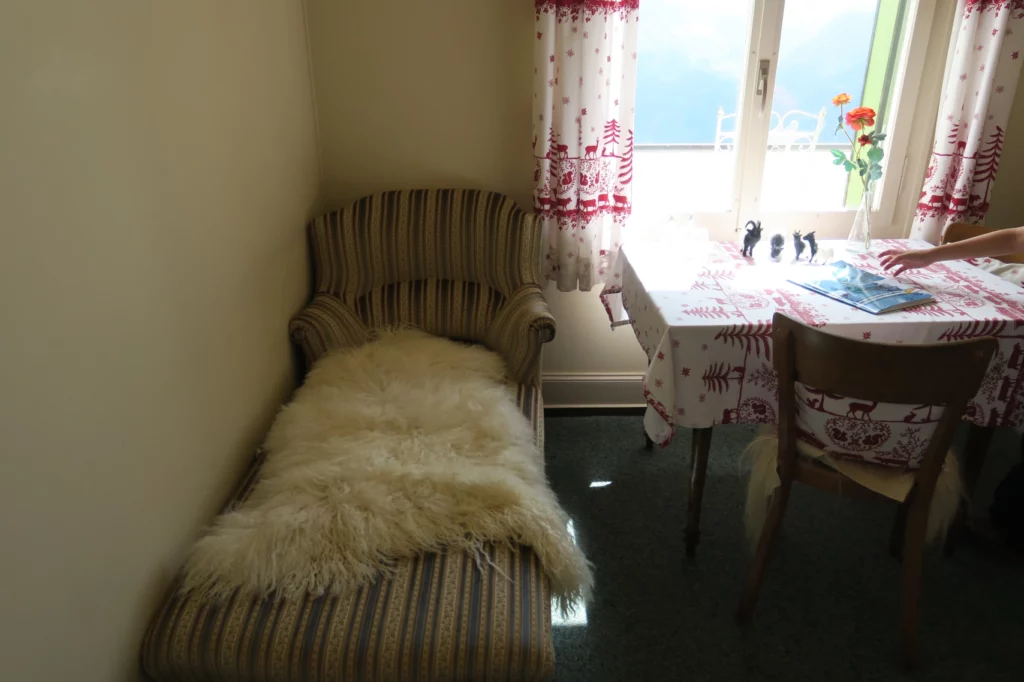 a couch with a fur blanket in a room with a table and chairs