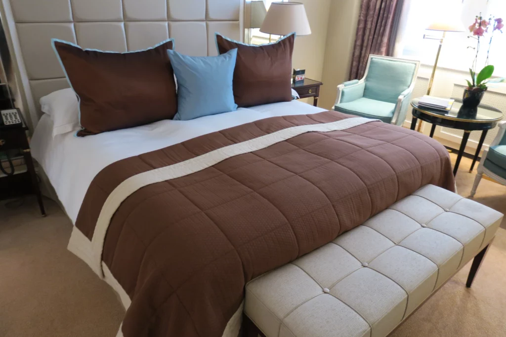 a bed with a brown blanket and blue pillows