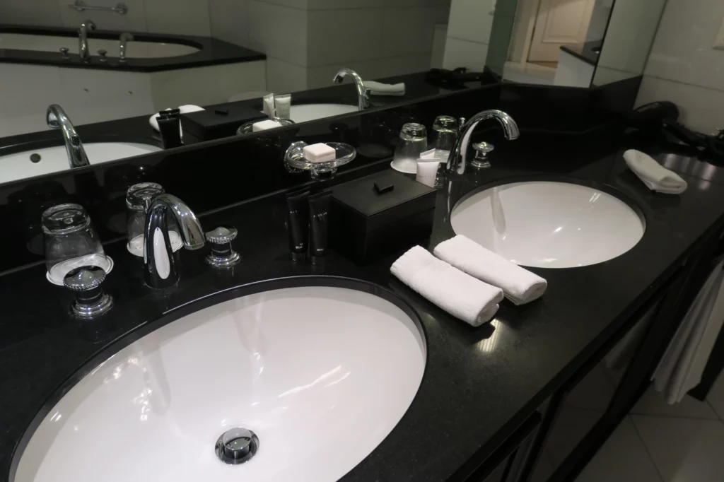 a bathroom with black countertop and white sinks