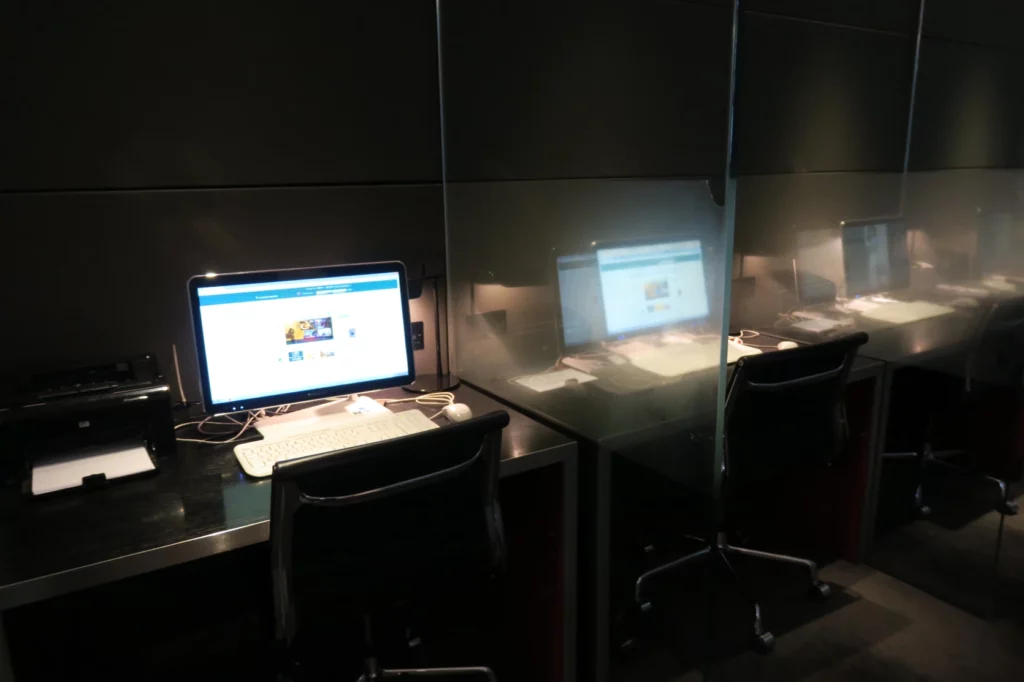 a computer desk with a screen behind it