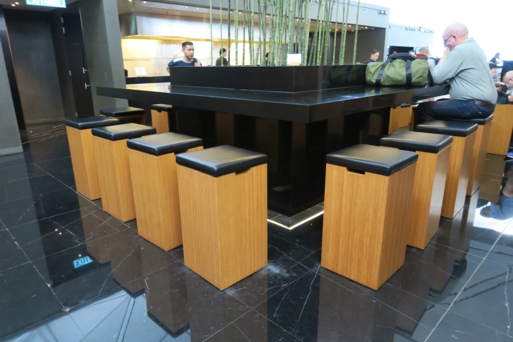 a black counter with wooden stools around it