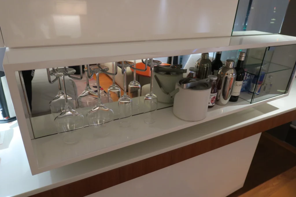 a shelf with wine glasses and bottles
