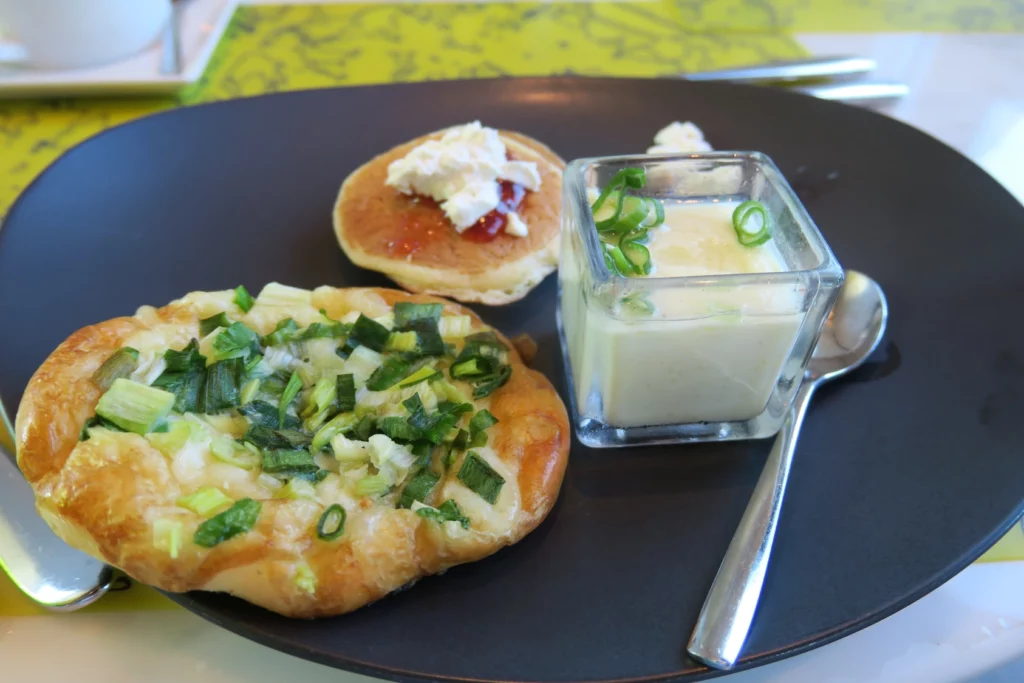 a plate of food with a spoon and a small pastry