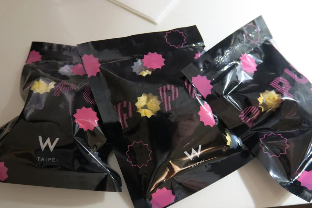 a group of black bags with pink and yellow designs