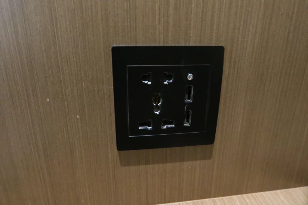 a black electrical outlet on a wood wall