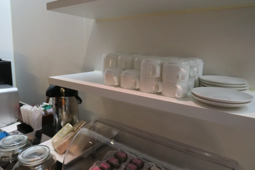 a shelf with white cups and plates