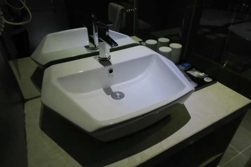 a white sink with a silver faucet