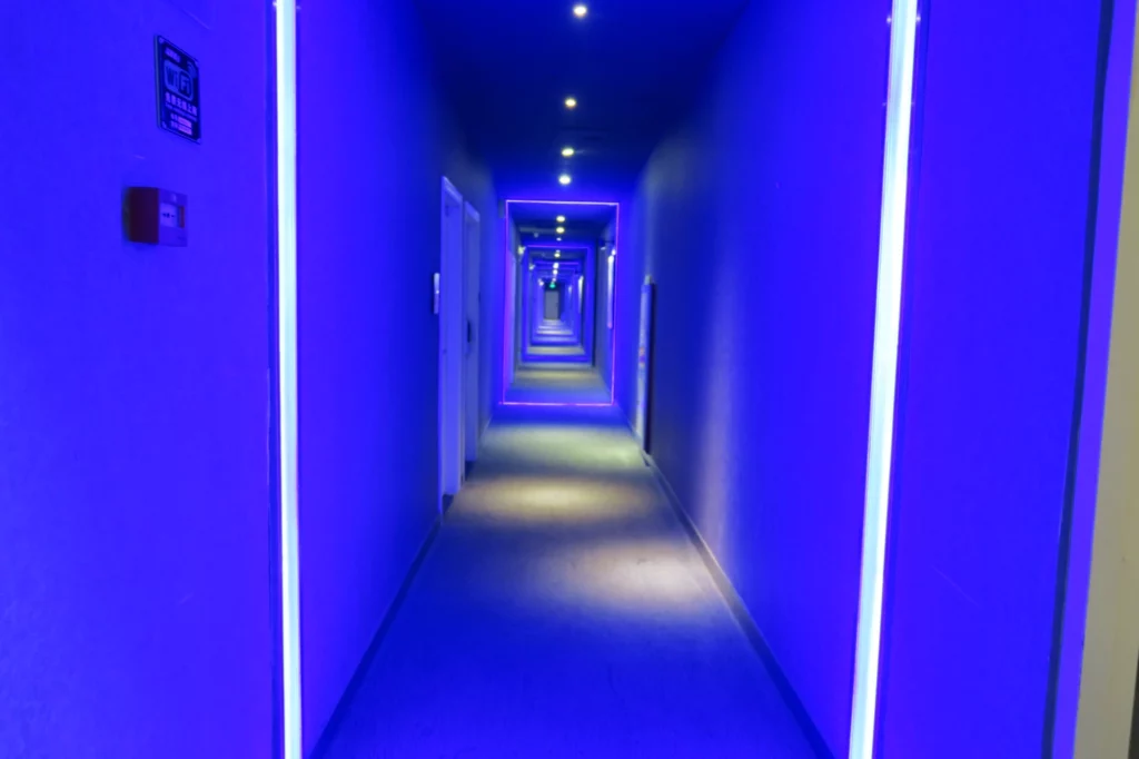 a long hallway with blue walls and lights