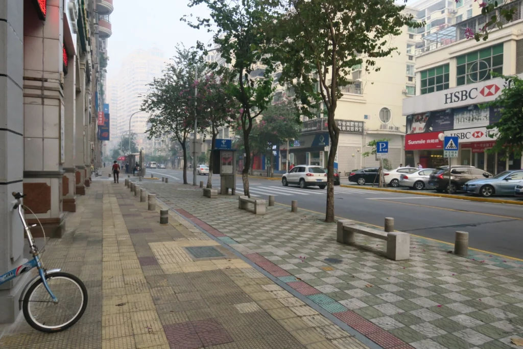 a sidewalk with trees and buildings on the side