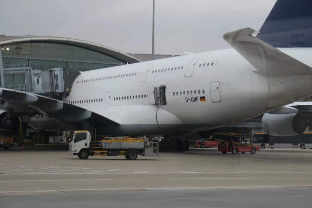 a large white airplane with a truck parked next to it