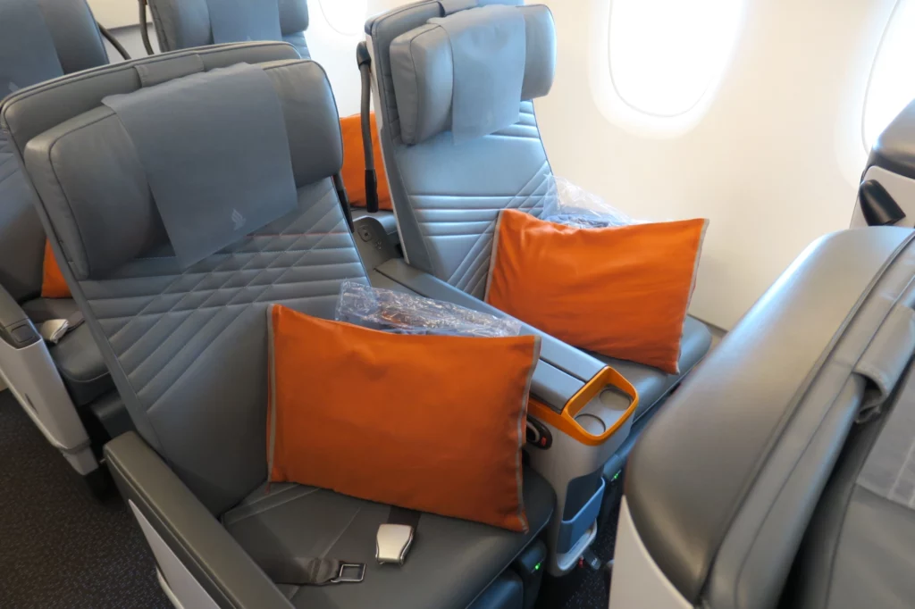 a seat with orange pillows on it
