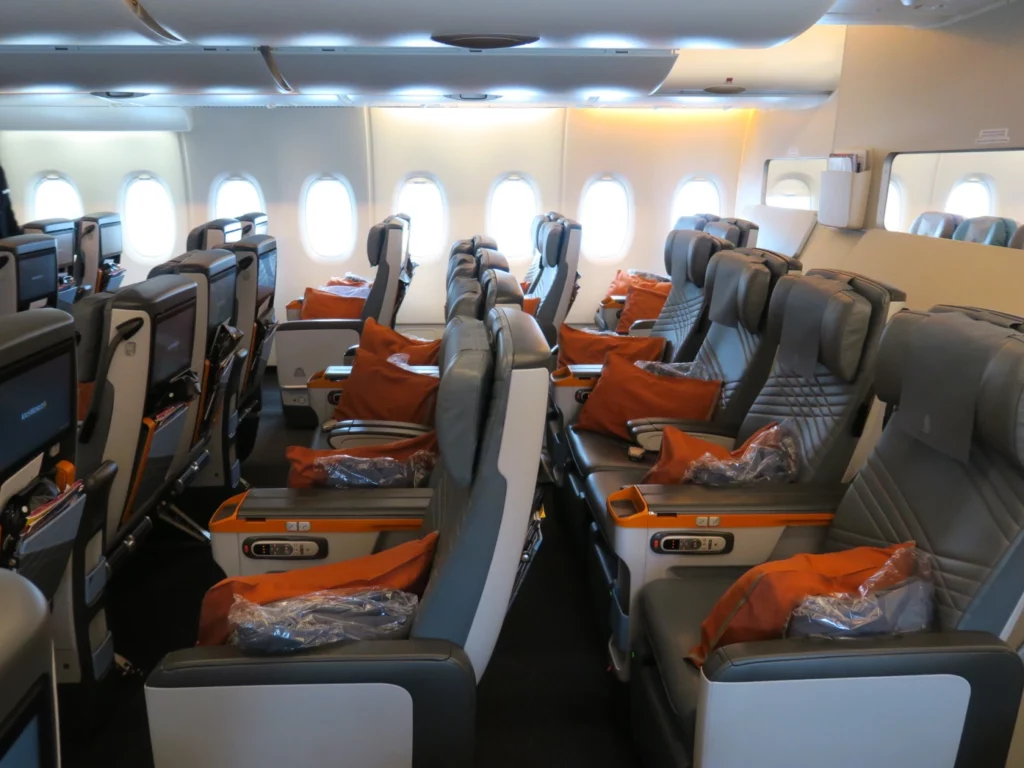 an airplane seats with orange pillows