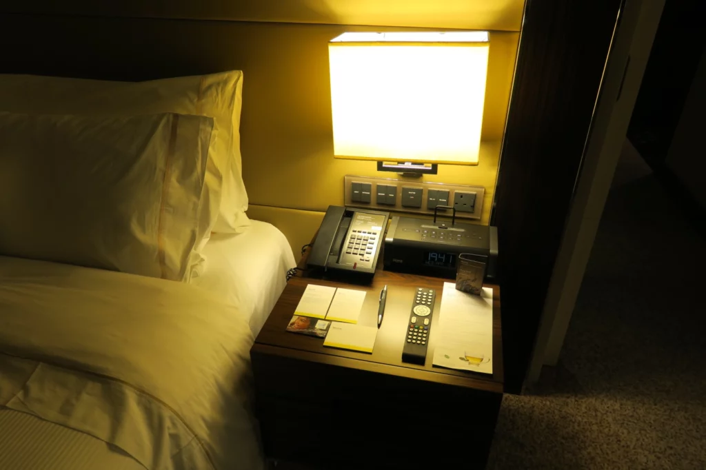 a bed with a lamp and telephone on a table