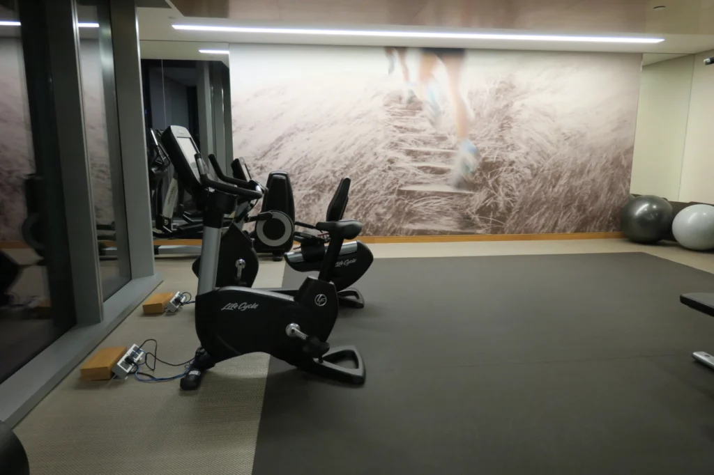 a room with exercise bikes and a large picture on the wall