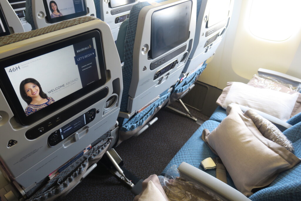 a row of seats with monitors and pillows on the side