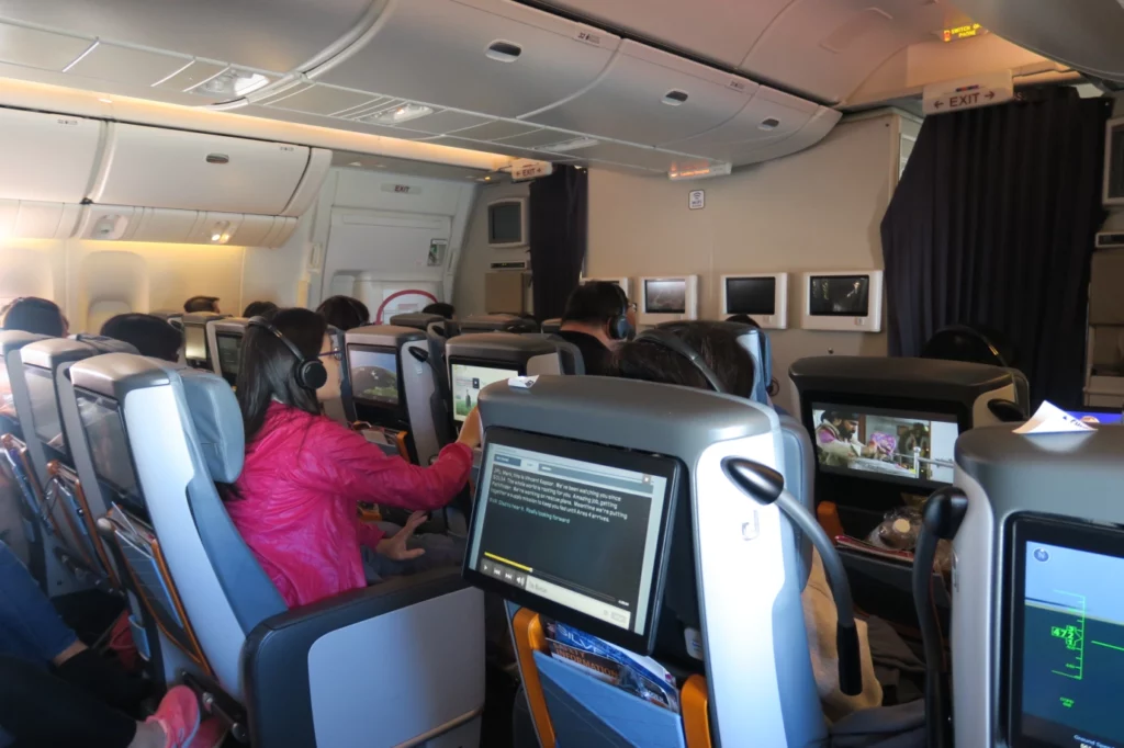 people sitting in an airplane with a group of people