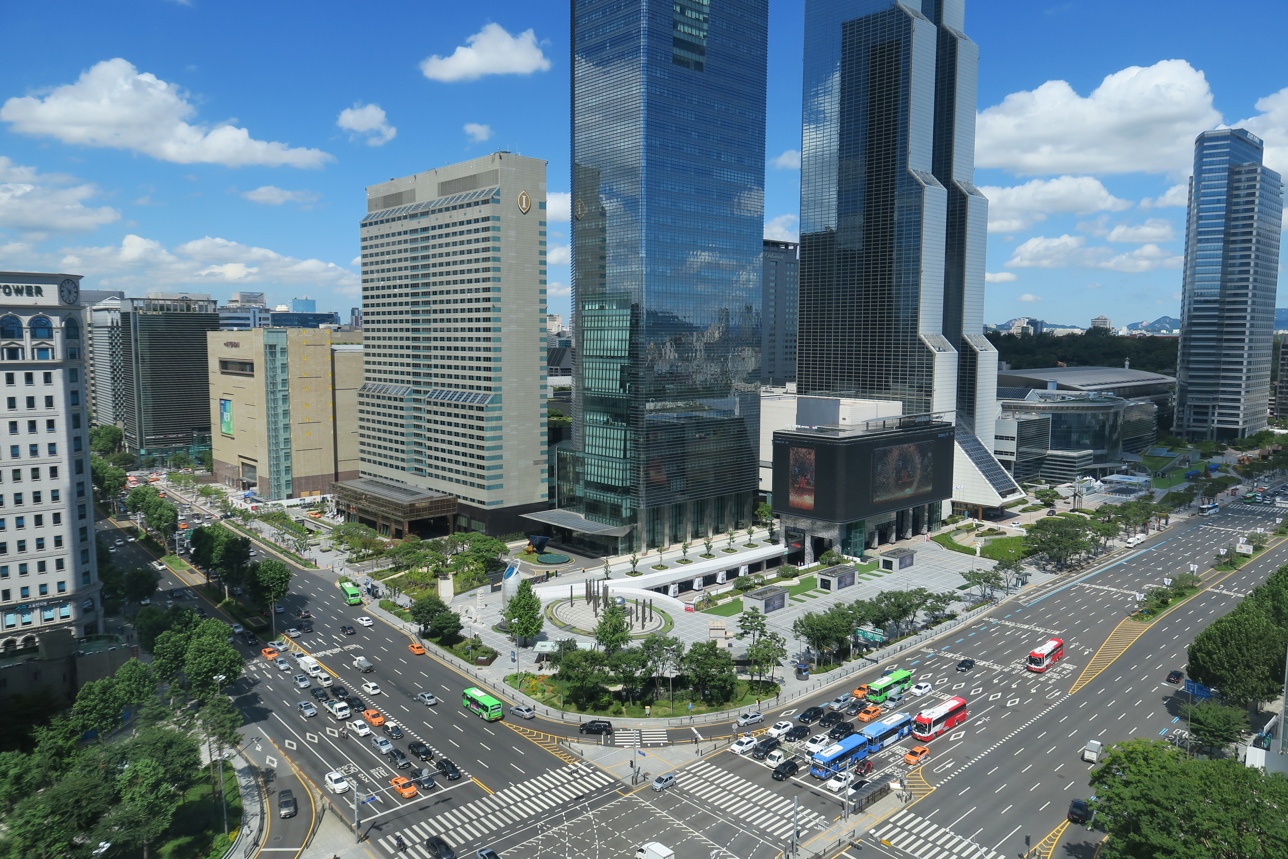 a city street with cars and skyscrapers
