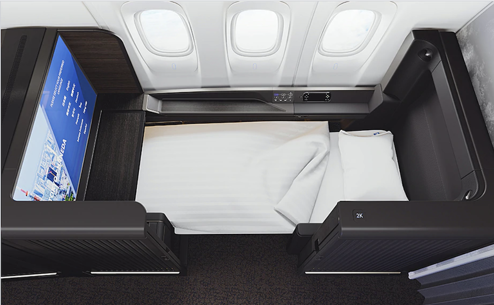an airplane bed with a white sheet and a white pillow