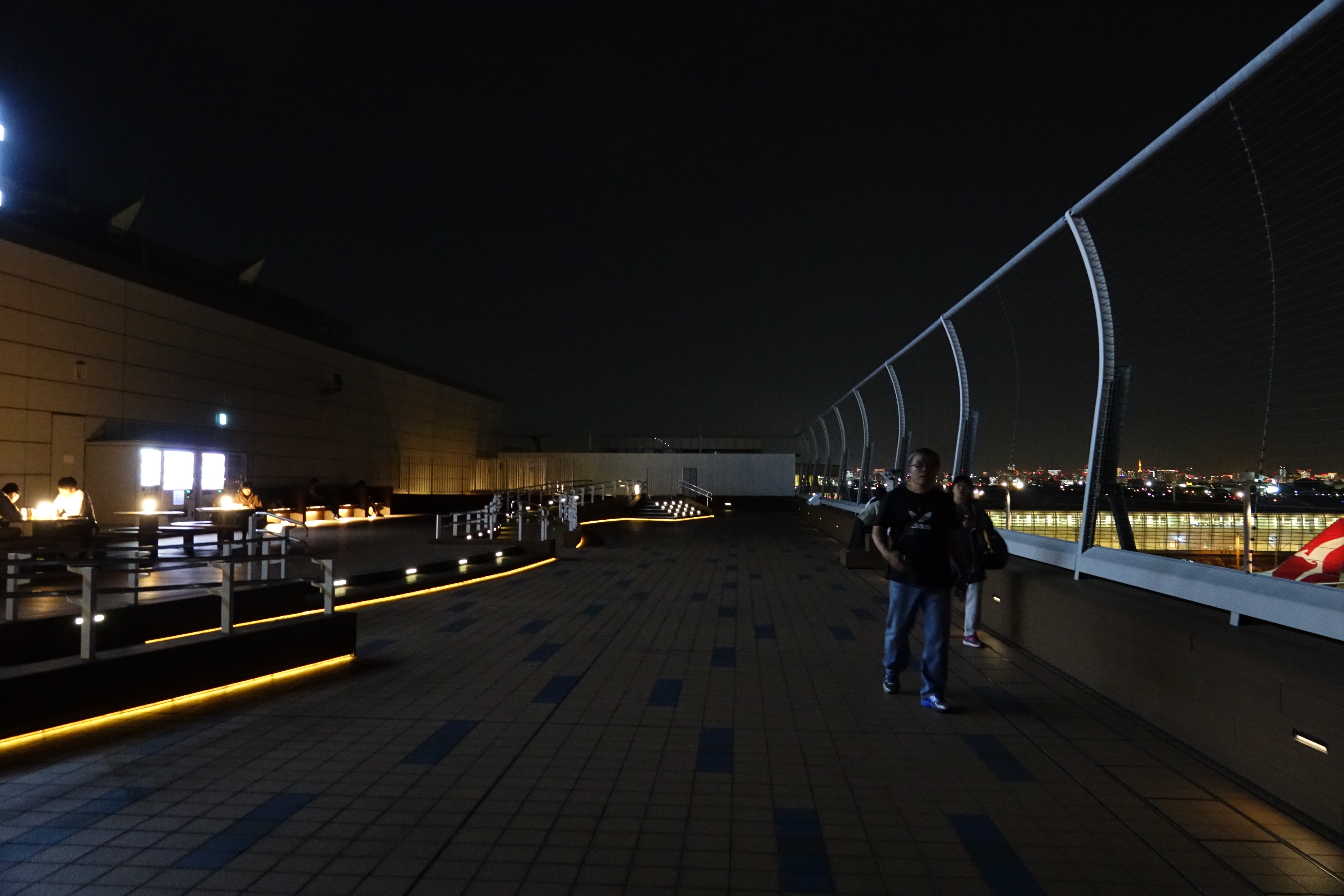 people standing on a walkway with lights on