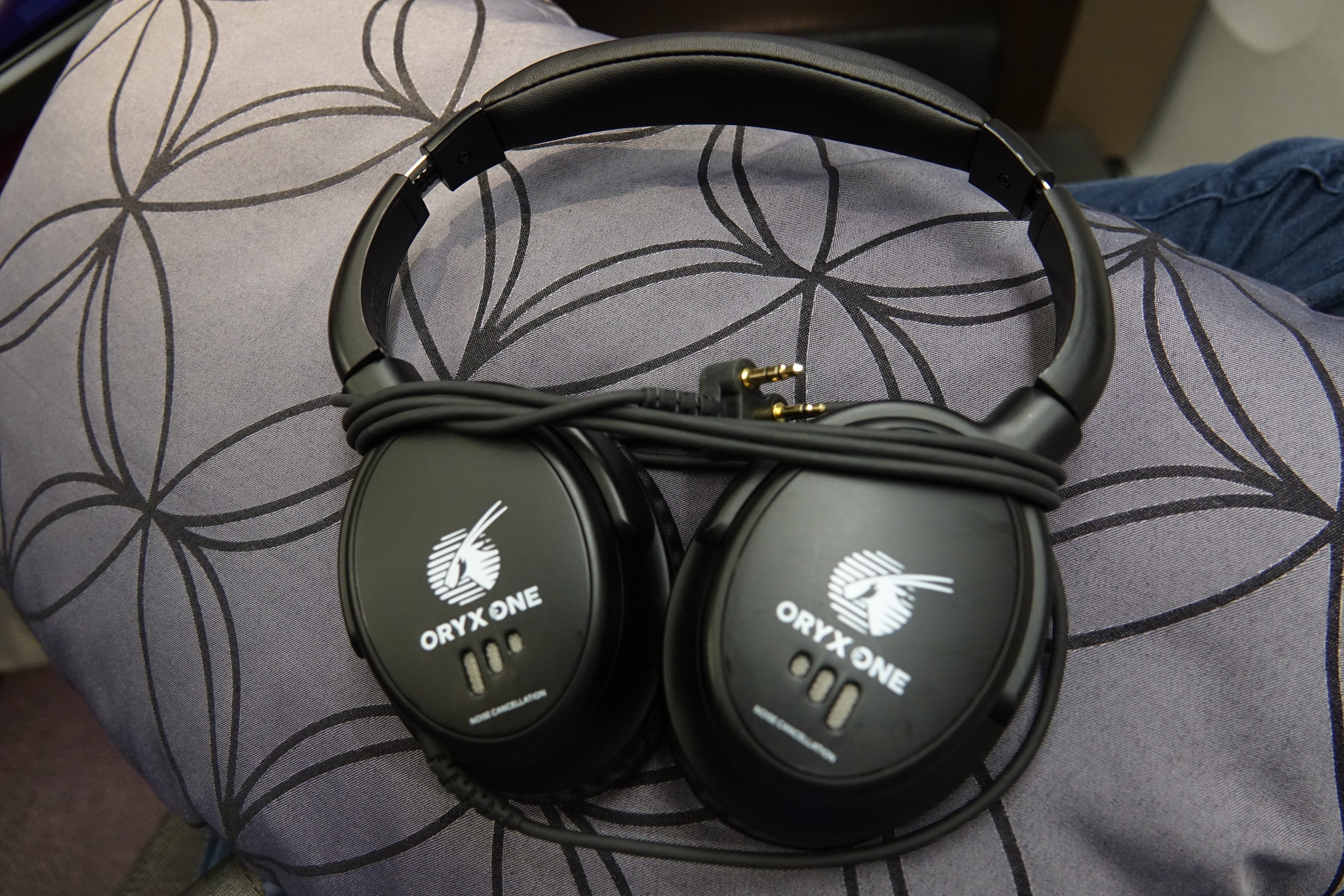 a pair of black headphones on a grey patterned surface