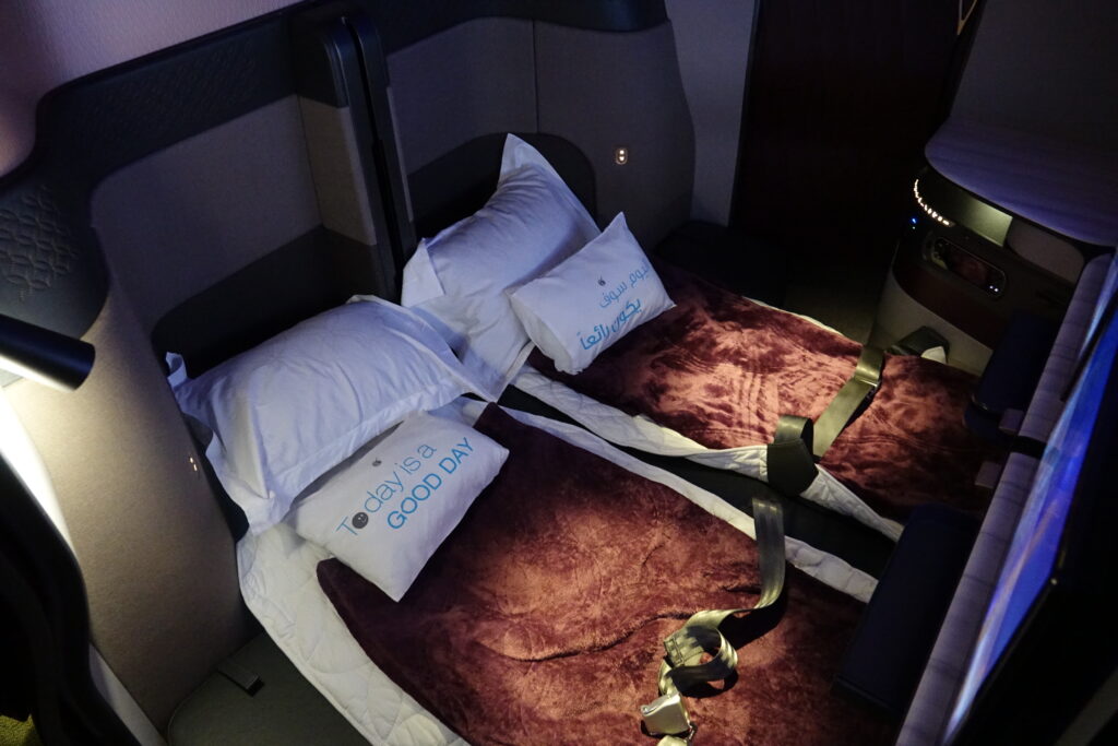 two beds with pillows and straps in a plane