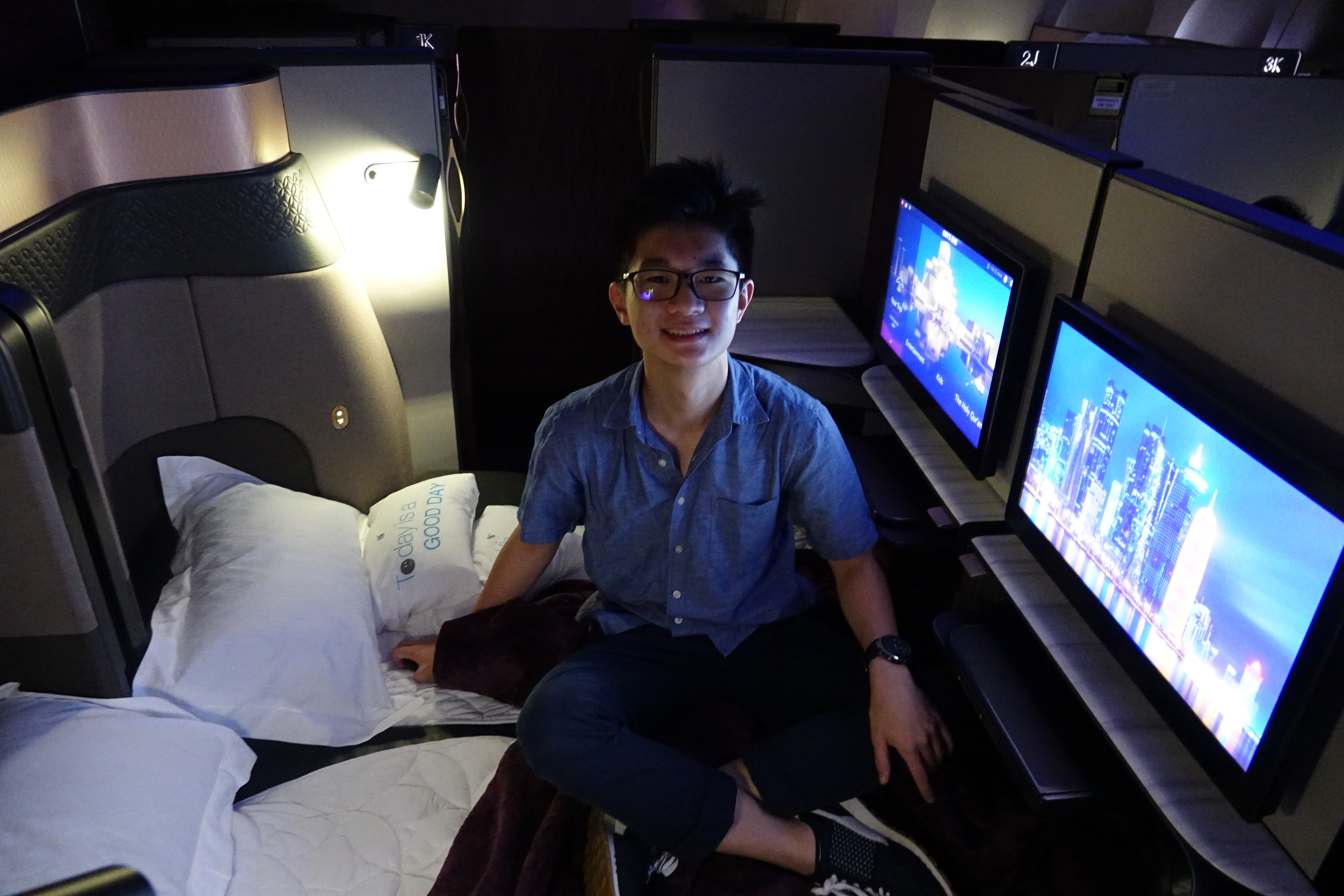 a man sitting on a bed with two monitors