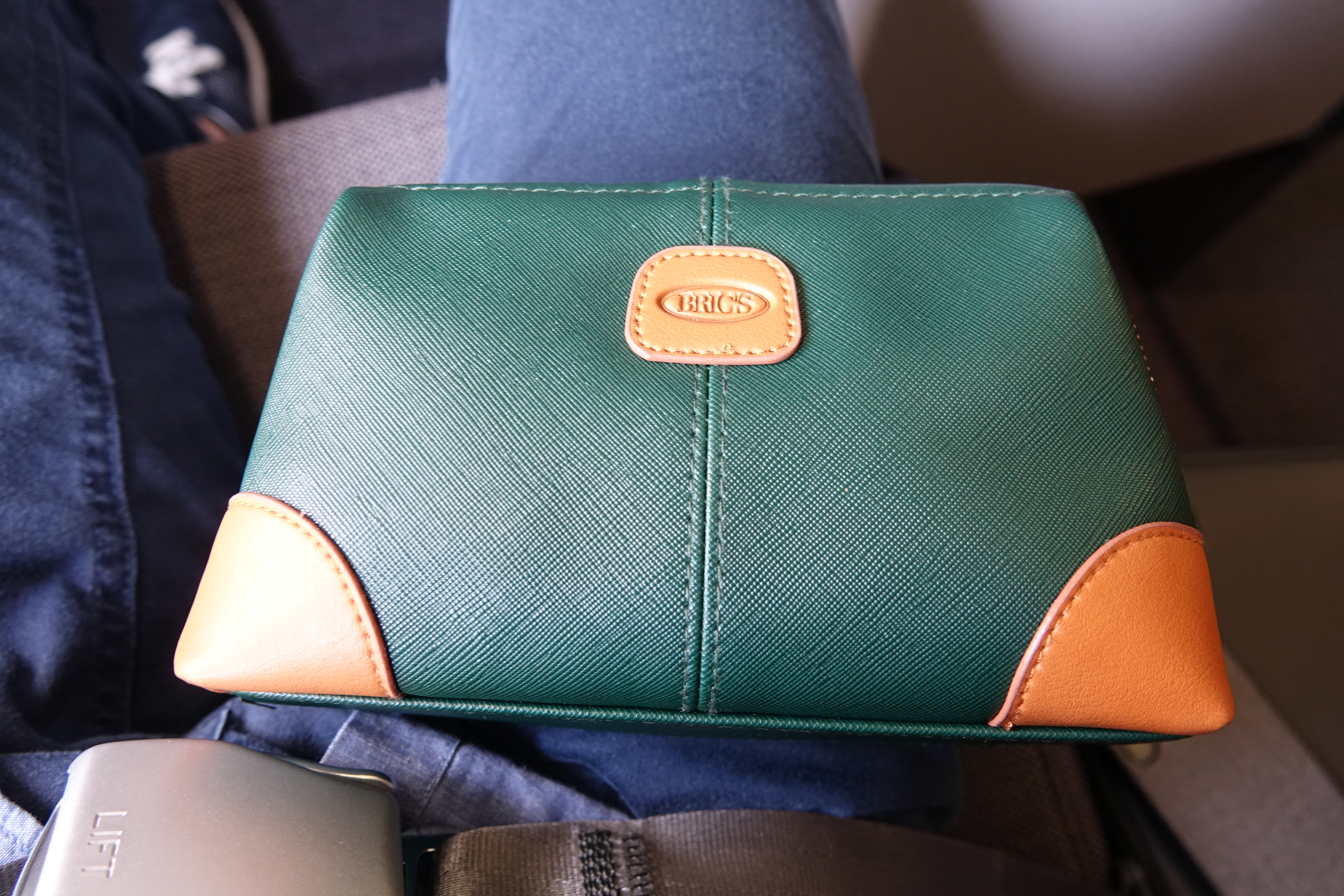 a green and orange bag on a person's lap