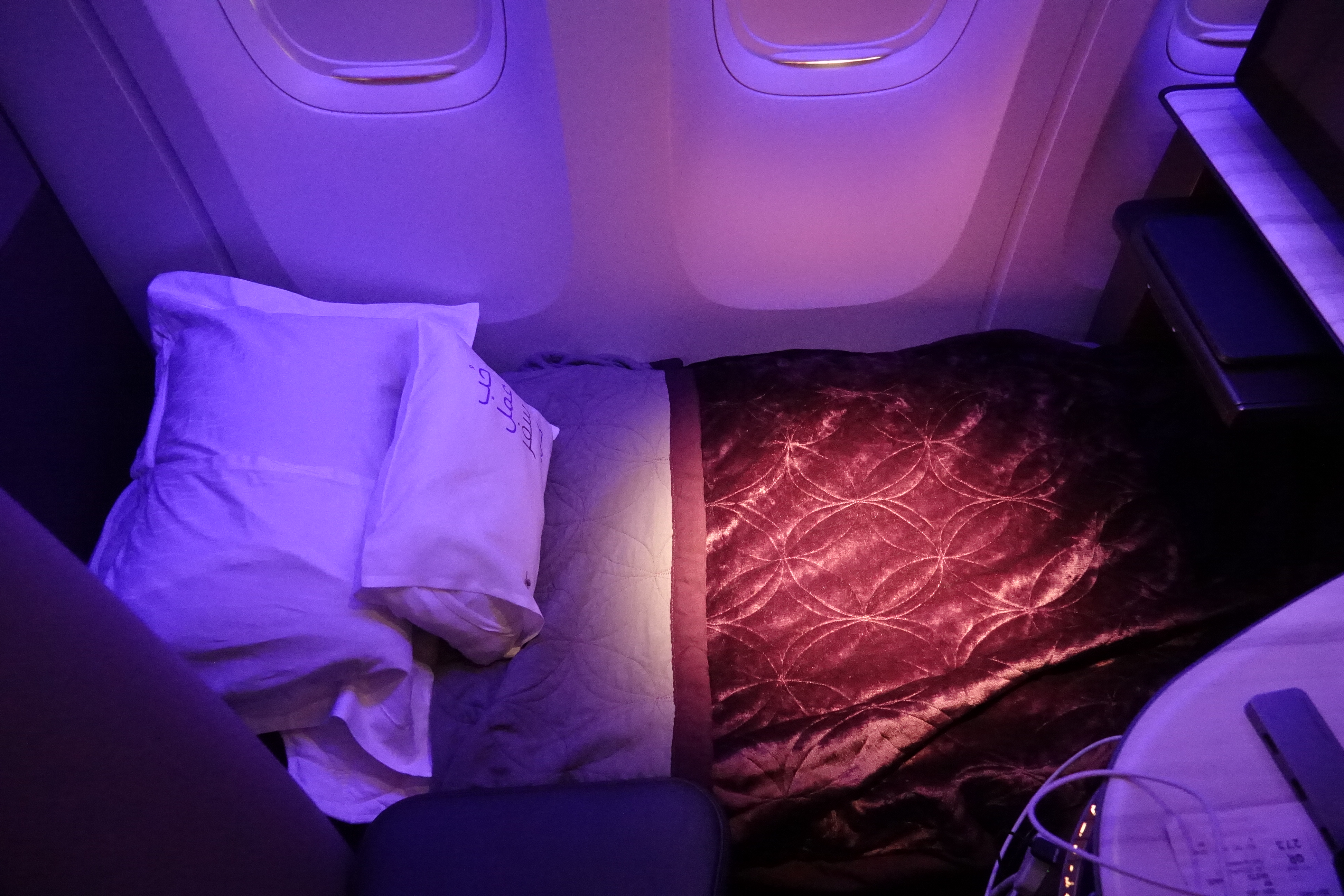 a bed with pillows and a fan in an airplane