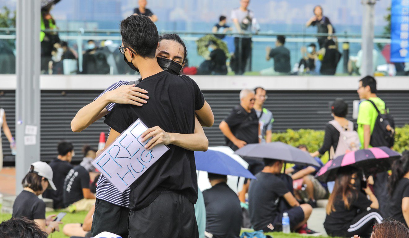 a man hugging another man with a sign