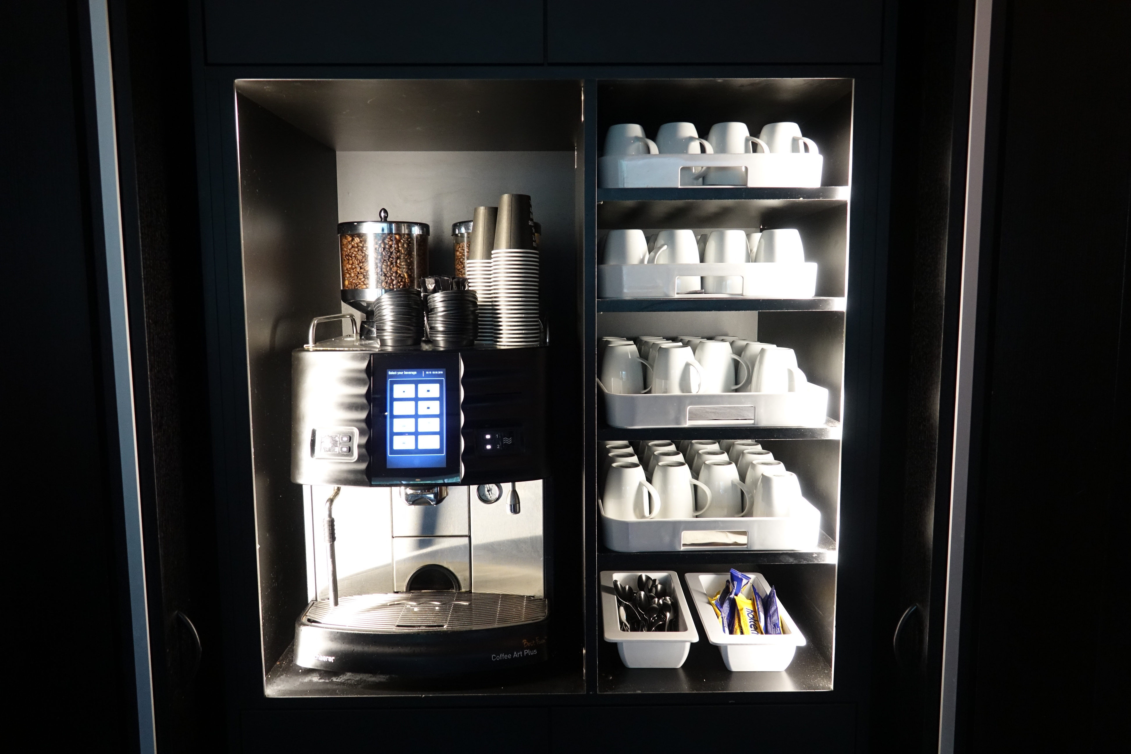 a coffee machine with cups and containers