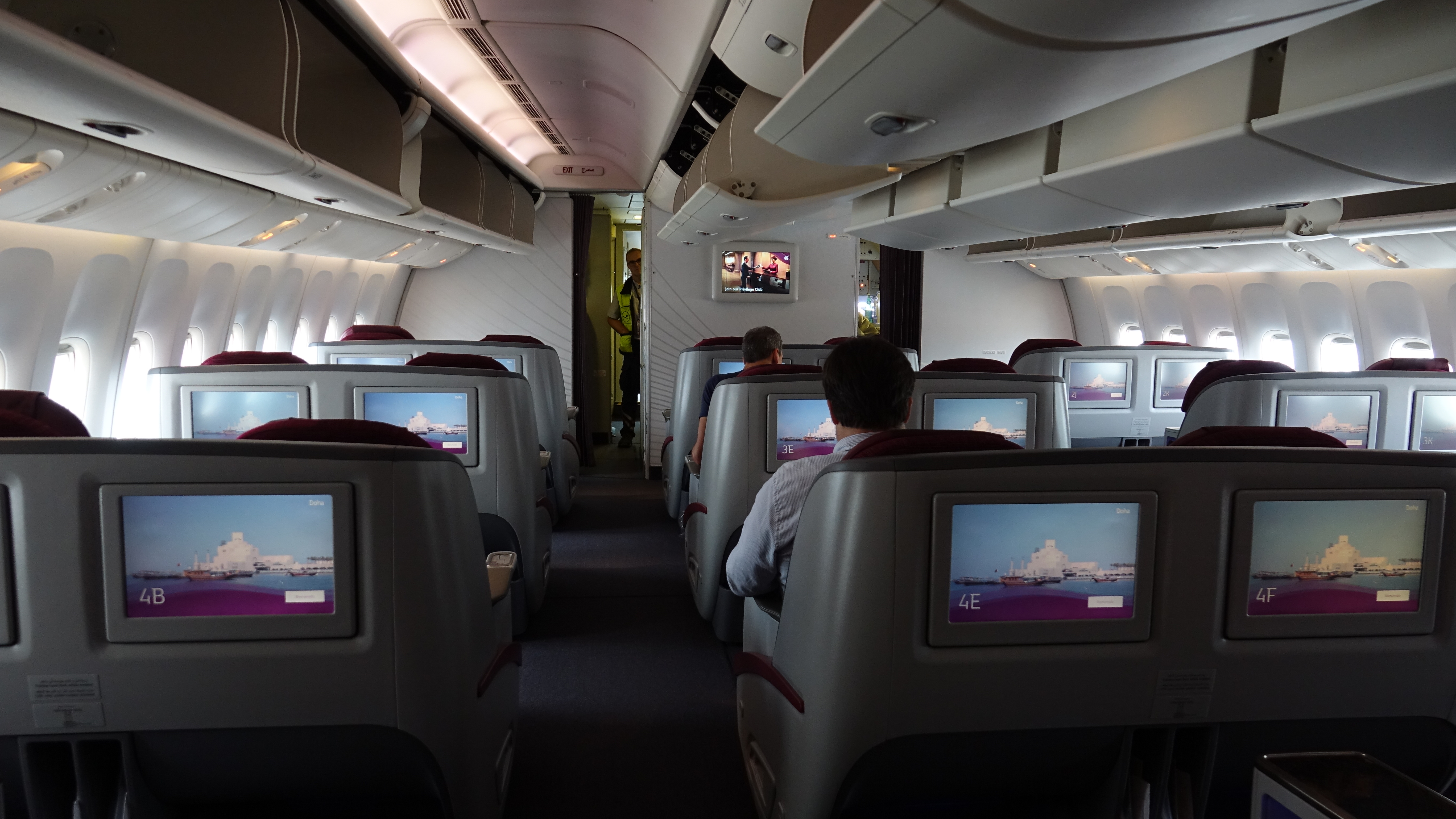 people sitting in an airplane with a television on the back
