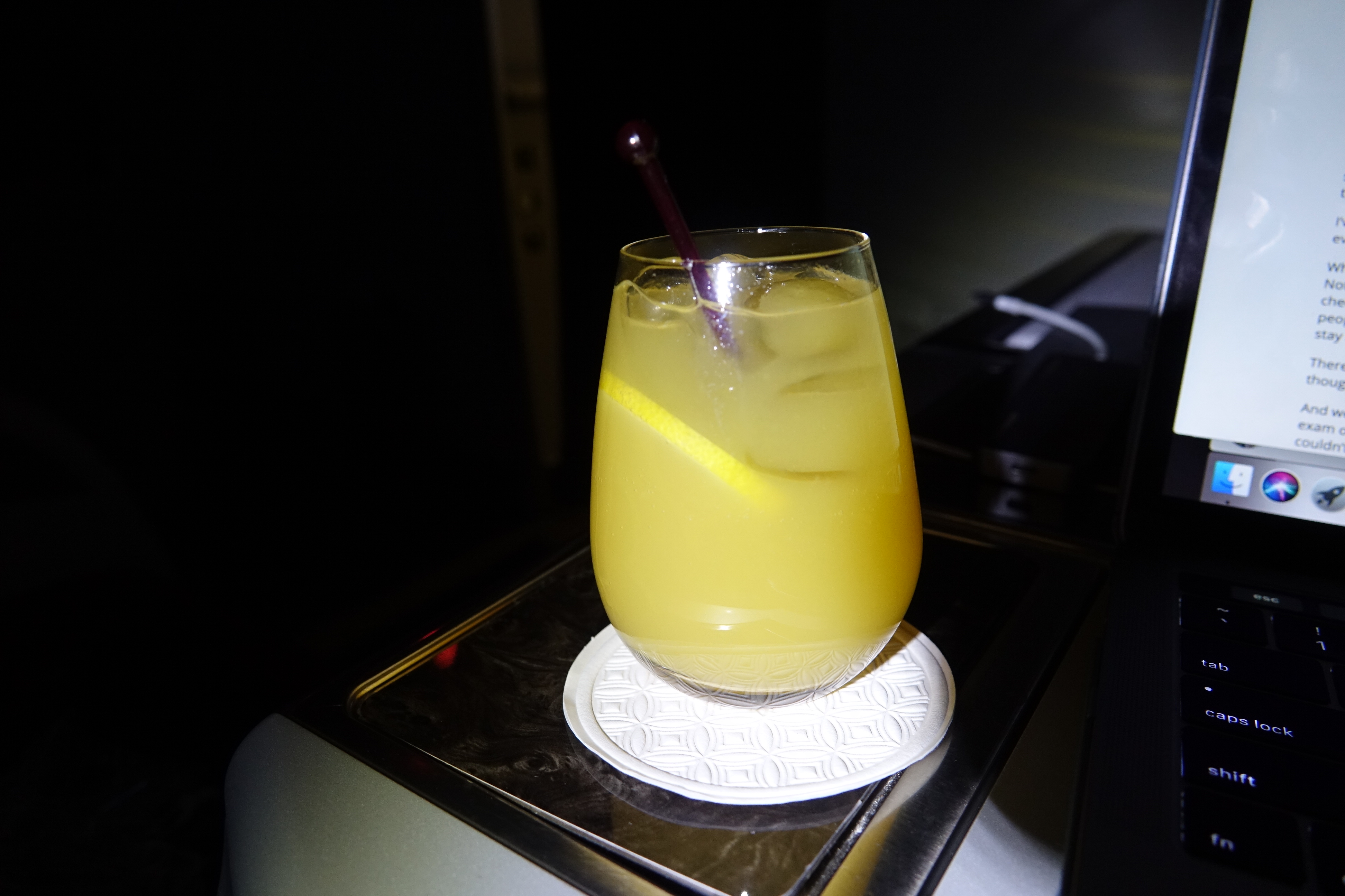 a glass of yellow liquid with a straw