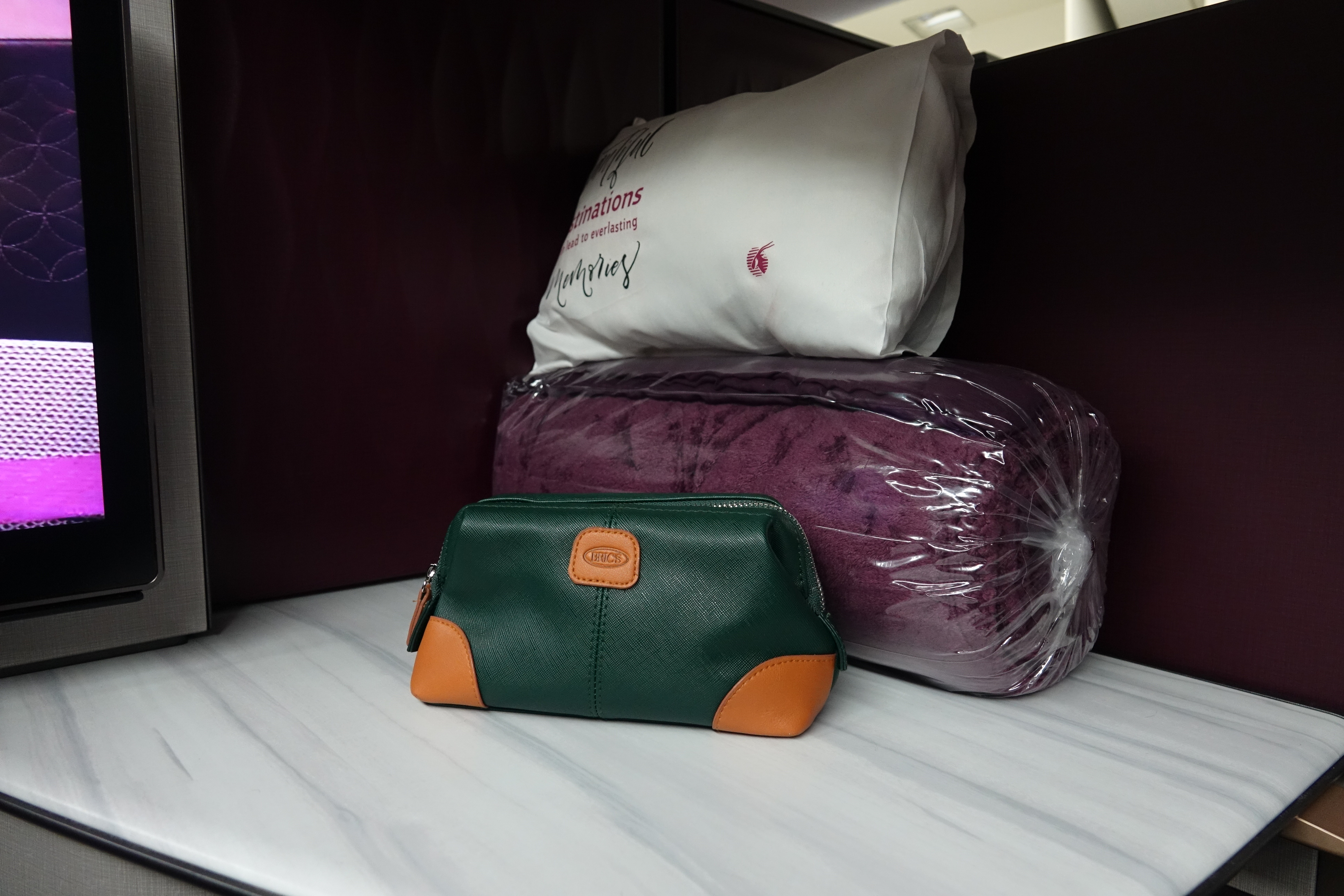 a green and white purse next to a purple pillow