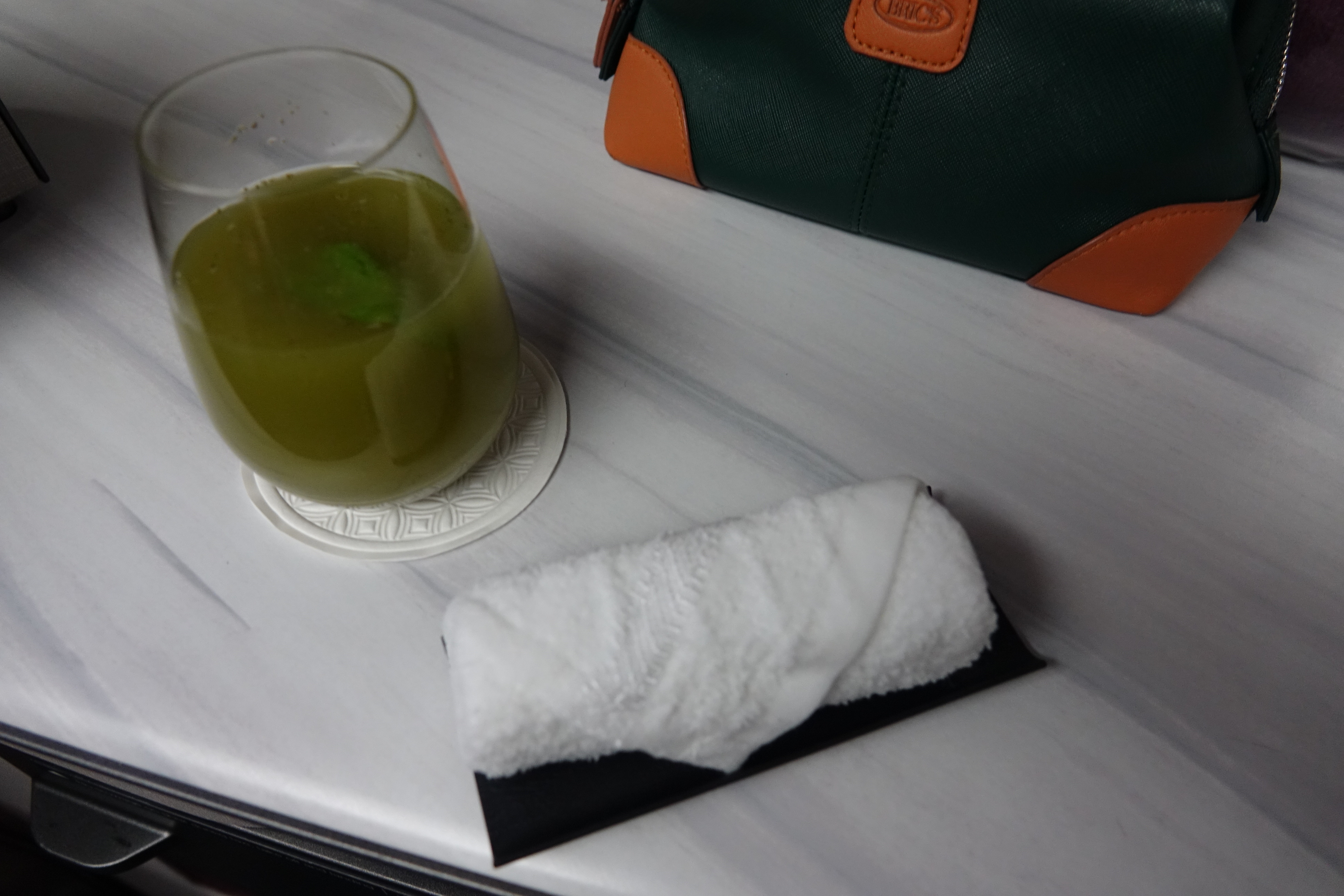 a towel on a plate next to a drink
