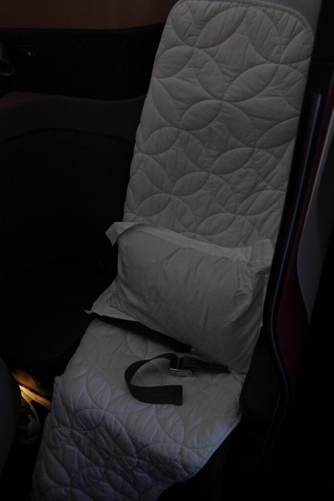 a seat with a pillow and a seat belt on it