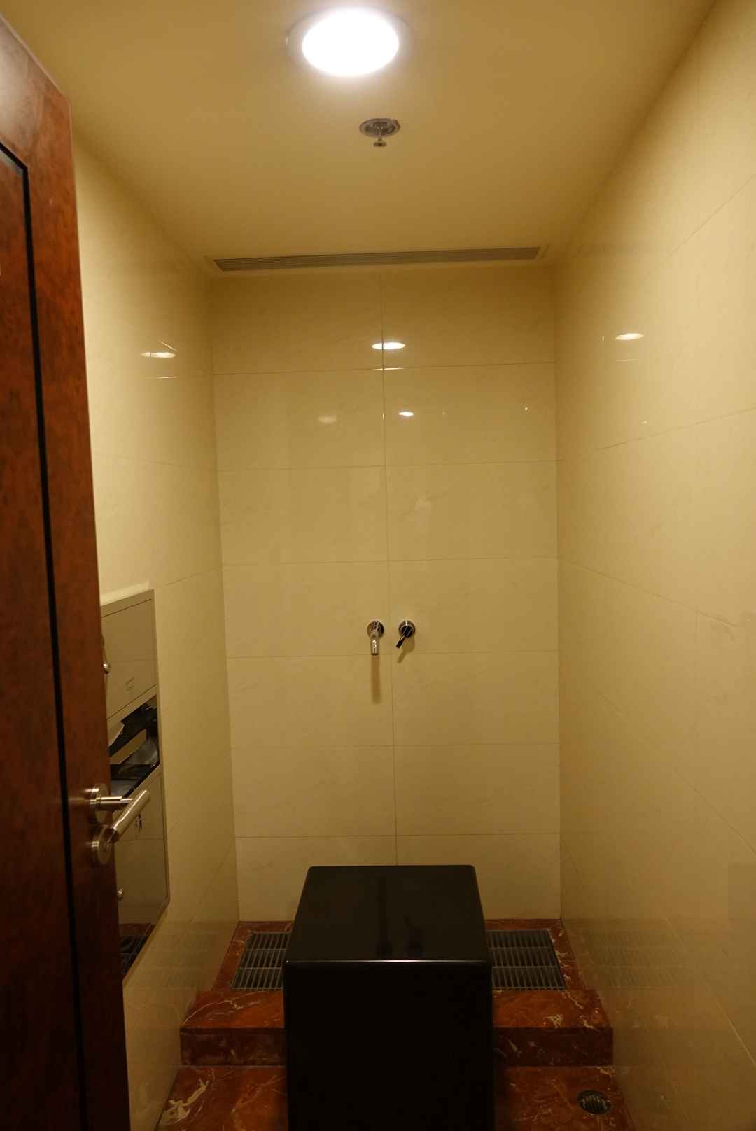 a shower with a black seat
