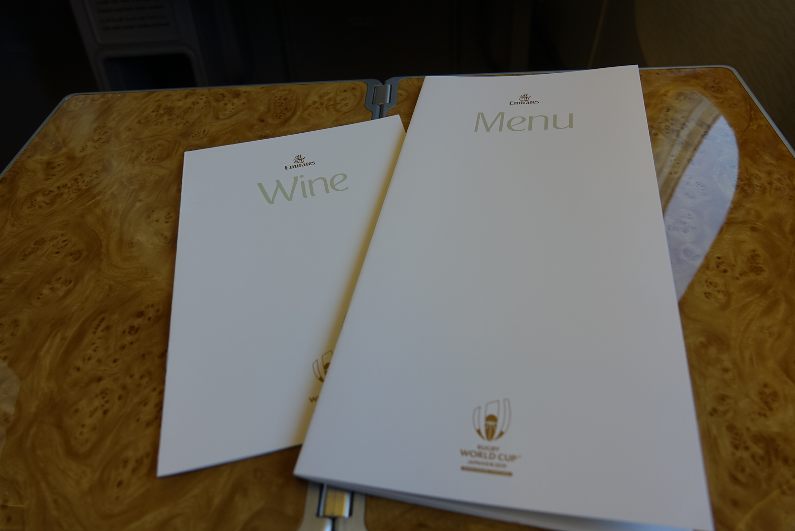 a couple of white menus on a wooden table
