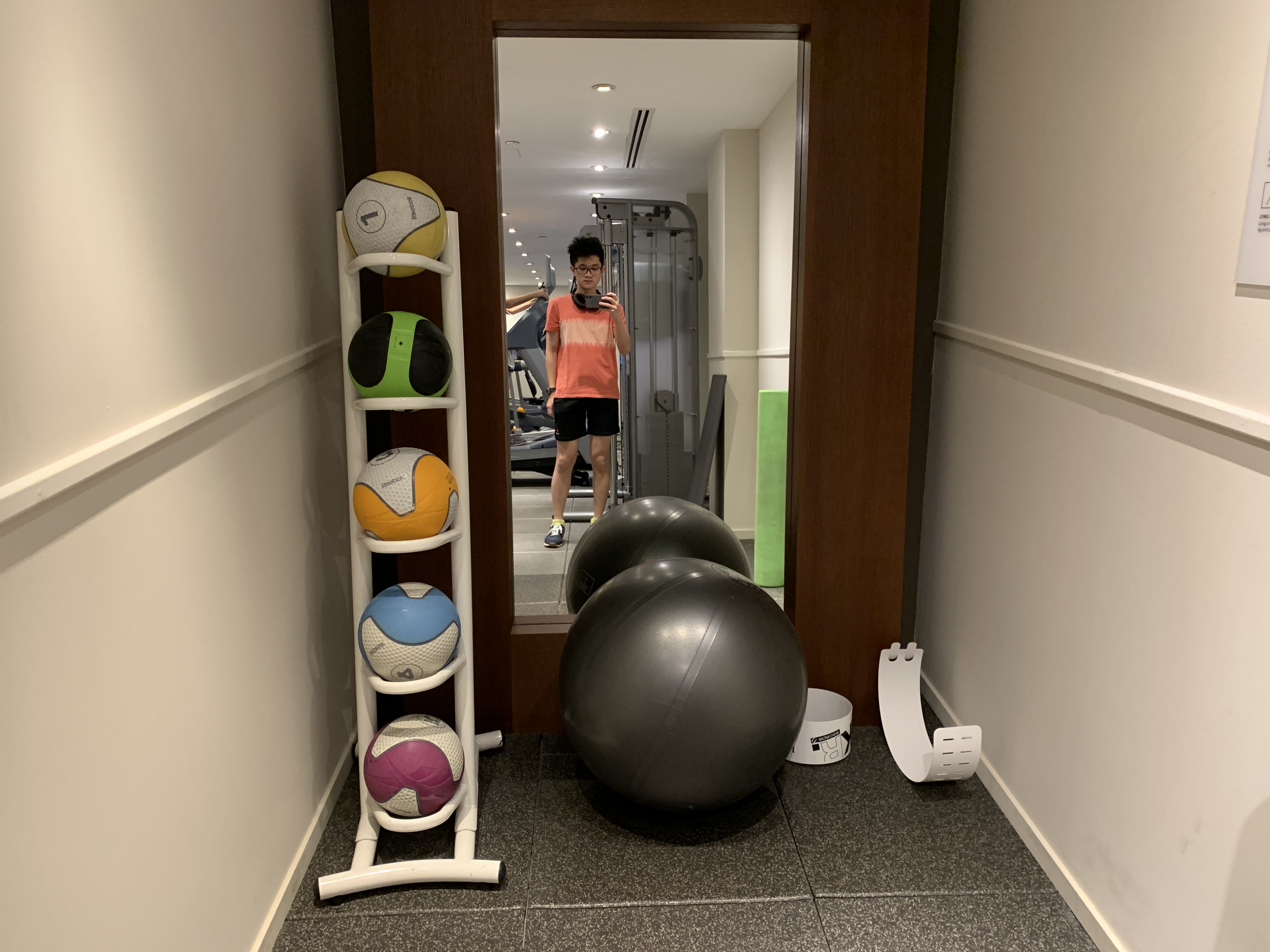 a person standing in front of a doorway with balls and a mirror