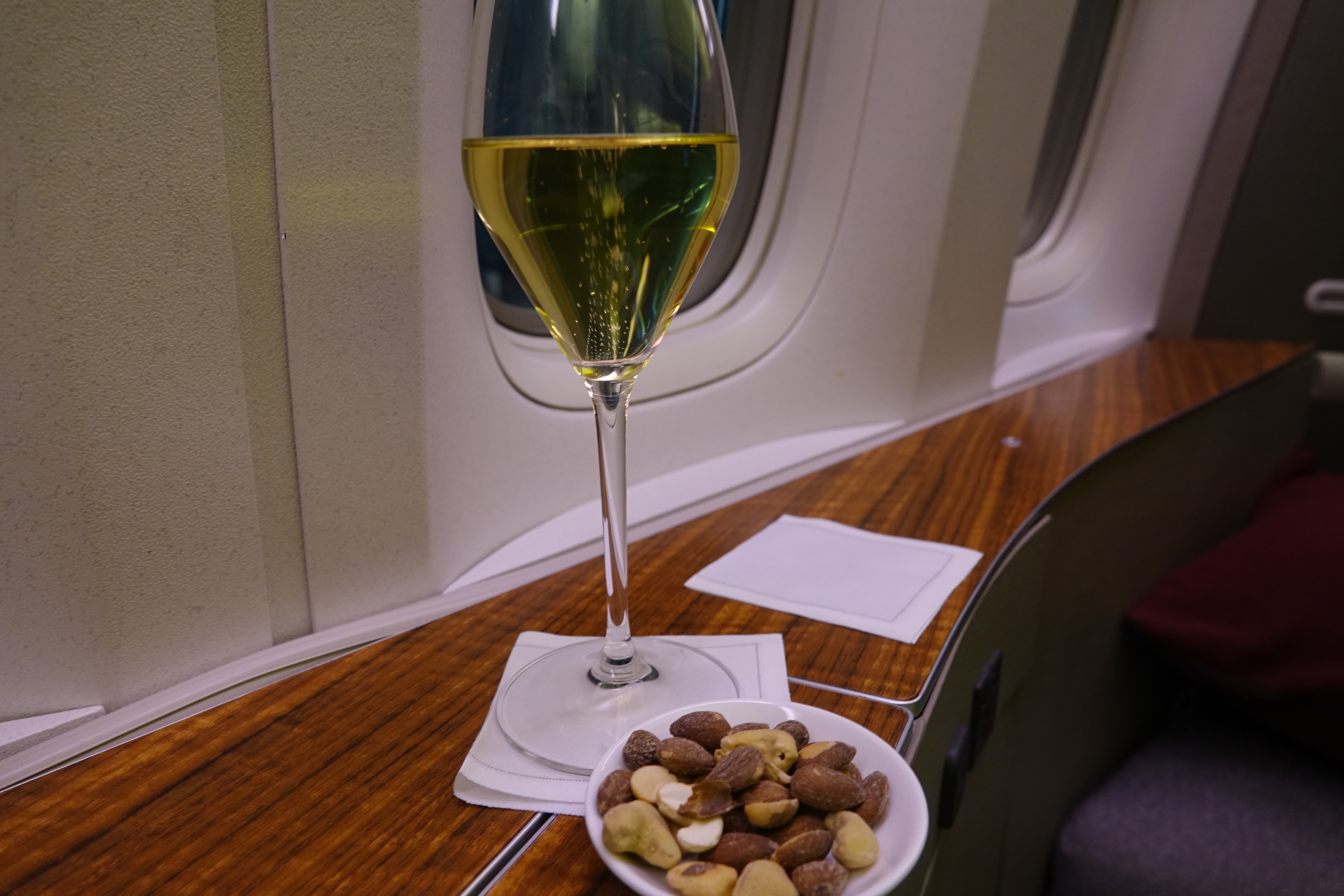 a glass of wine and a bowl of nuts on a table