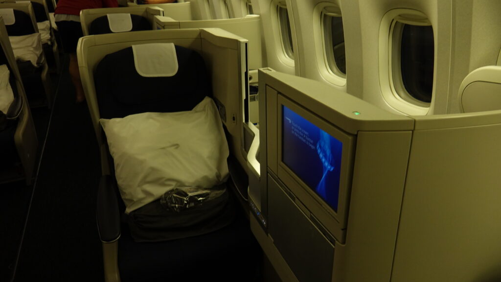 a seat with a pillow and a monitor on the side of the seat