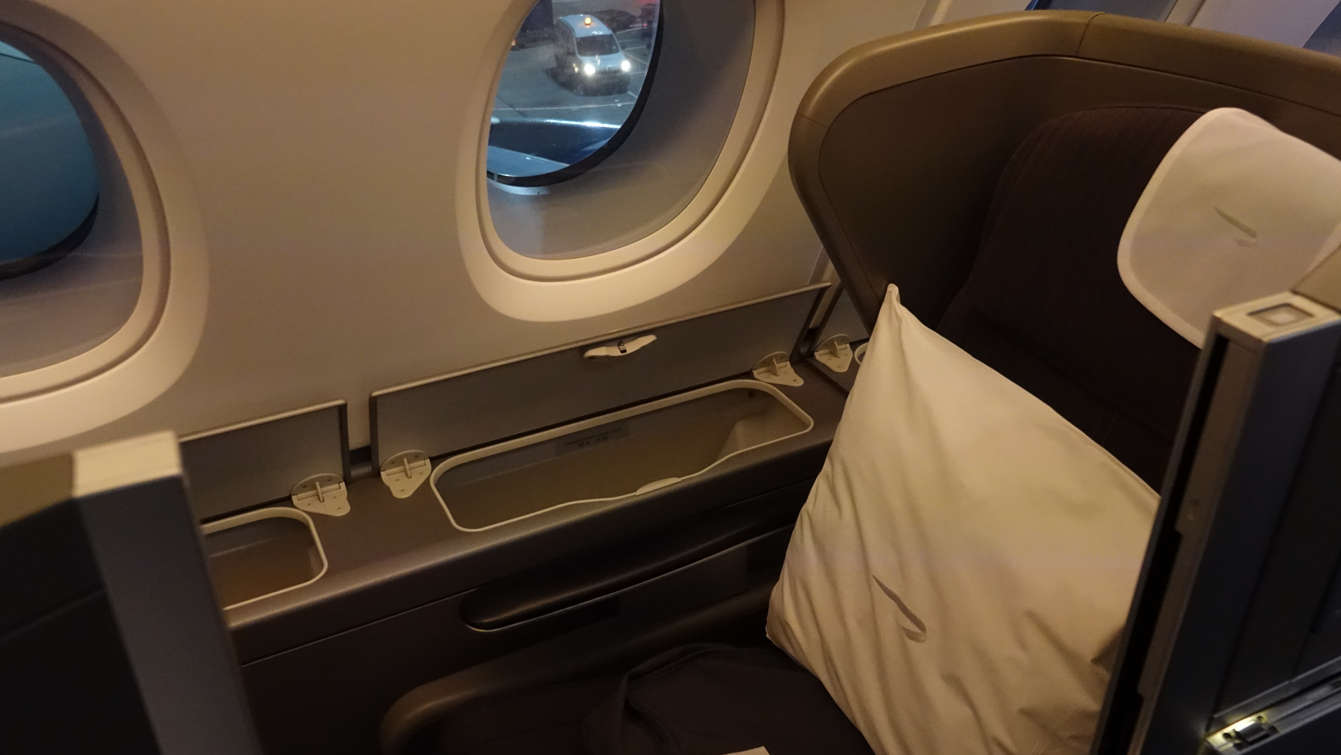 a window with a pillow and a pillow on the side of a plane