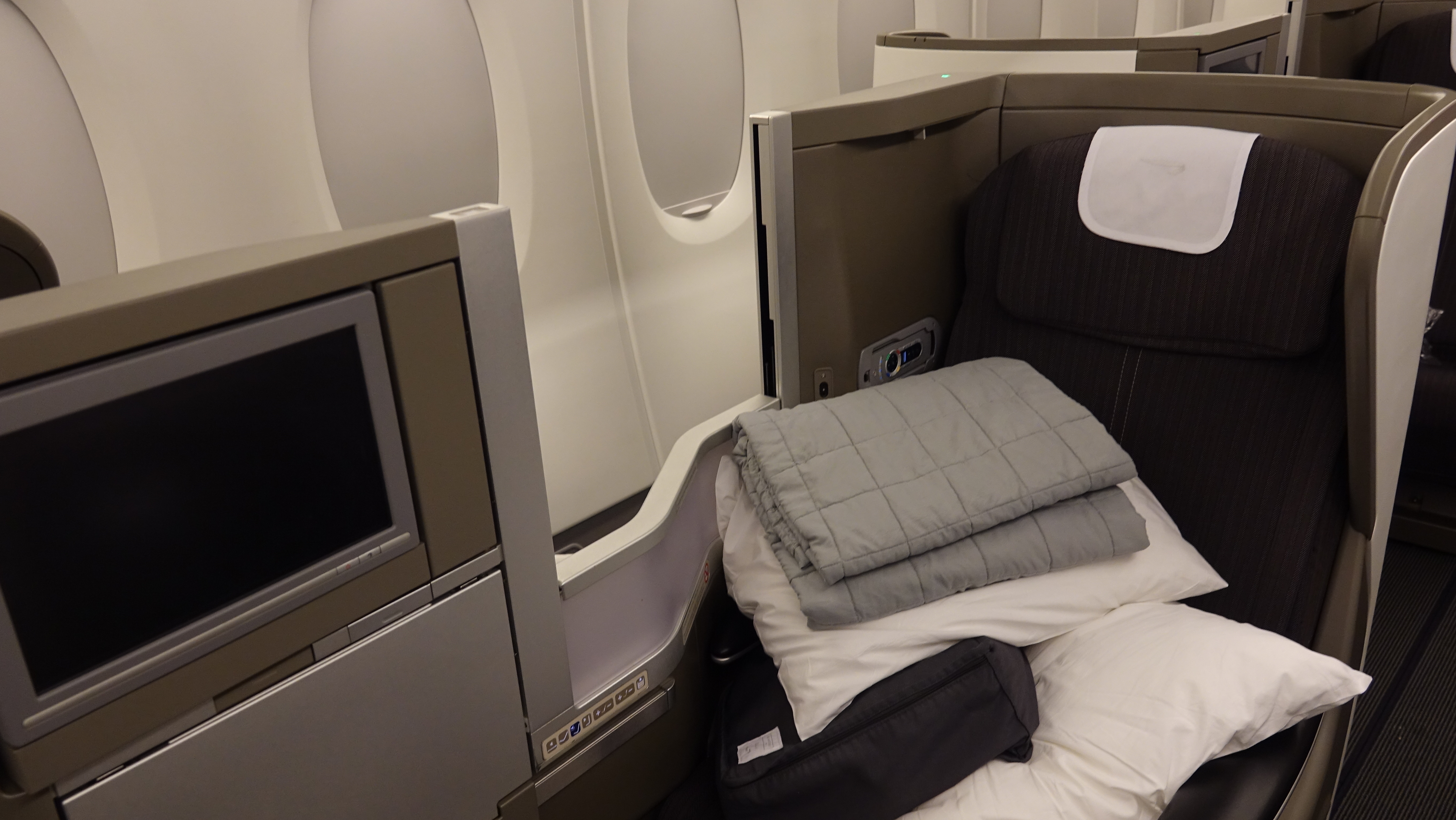a bed with blankets and pillows in an airplane