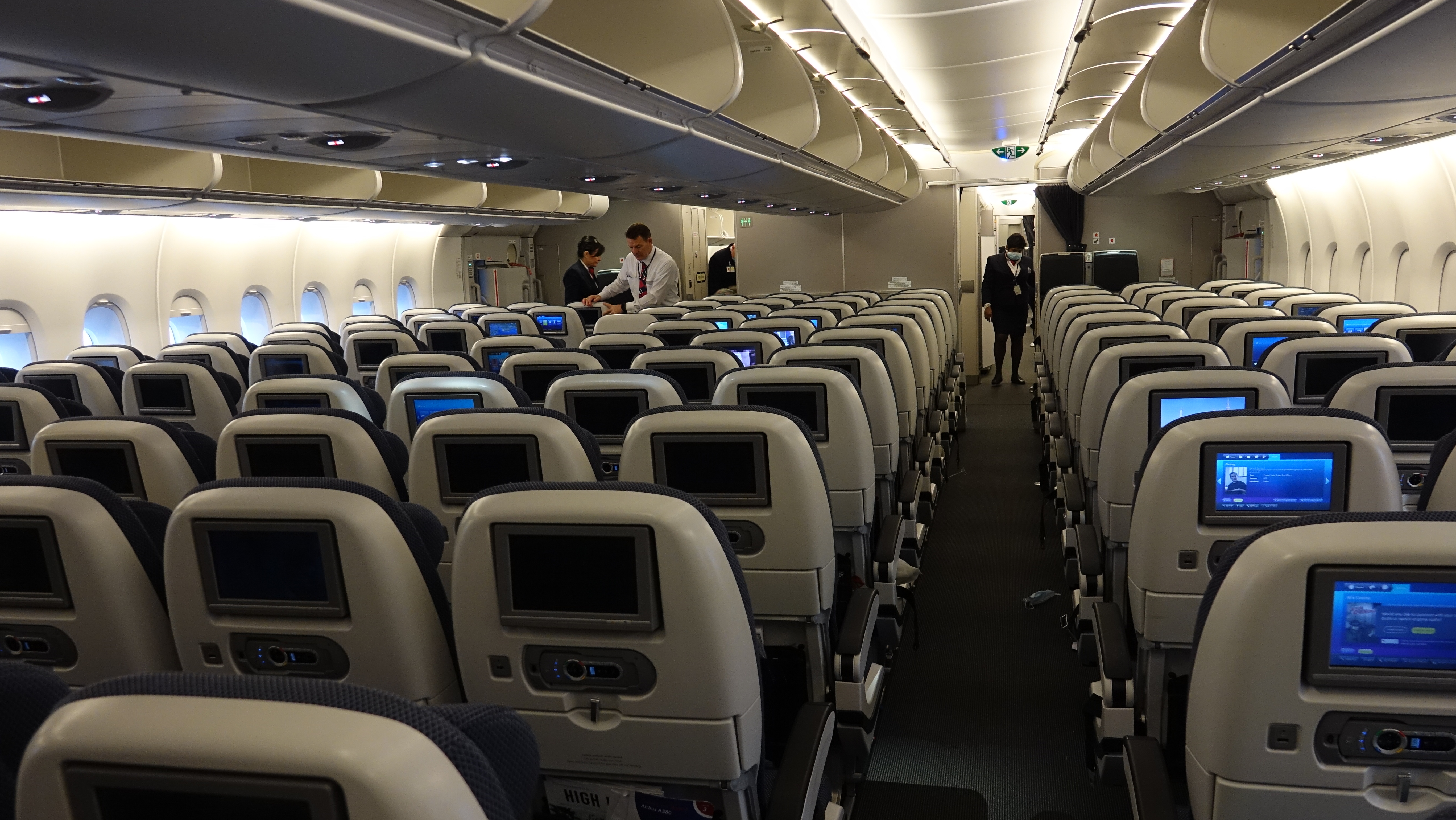 a plane with rows of seats and people in the back