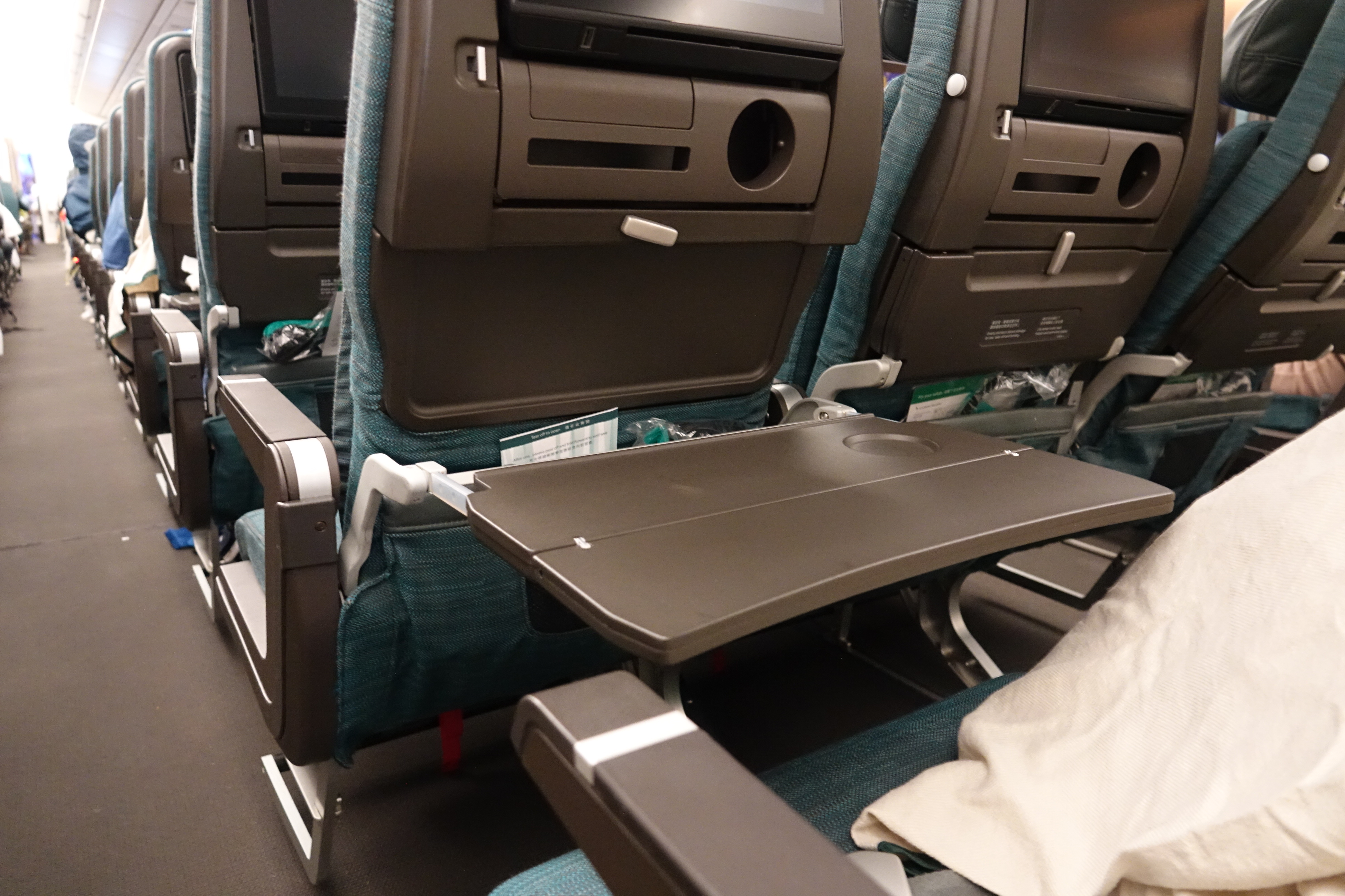 an airplane seat with a table and a tv
