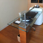 a glass desk with a metal bar on it