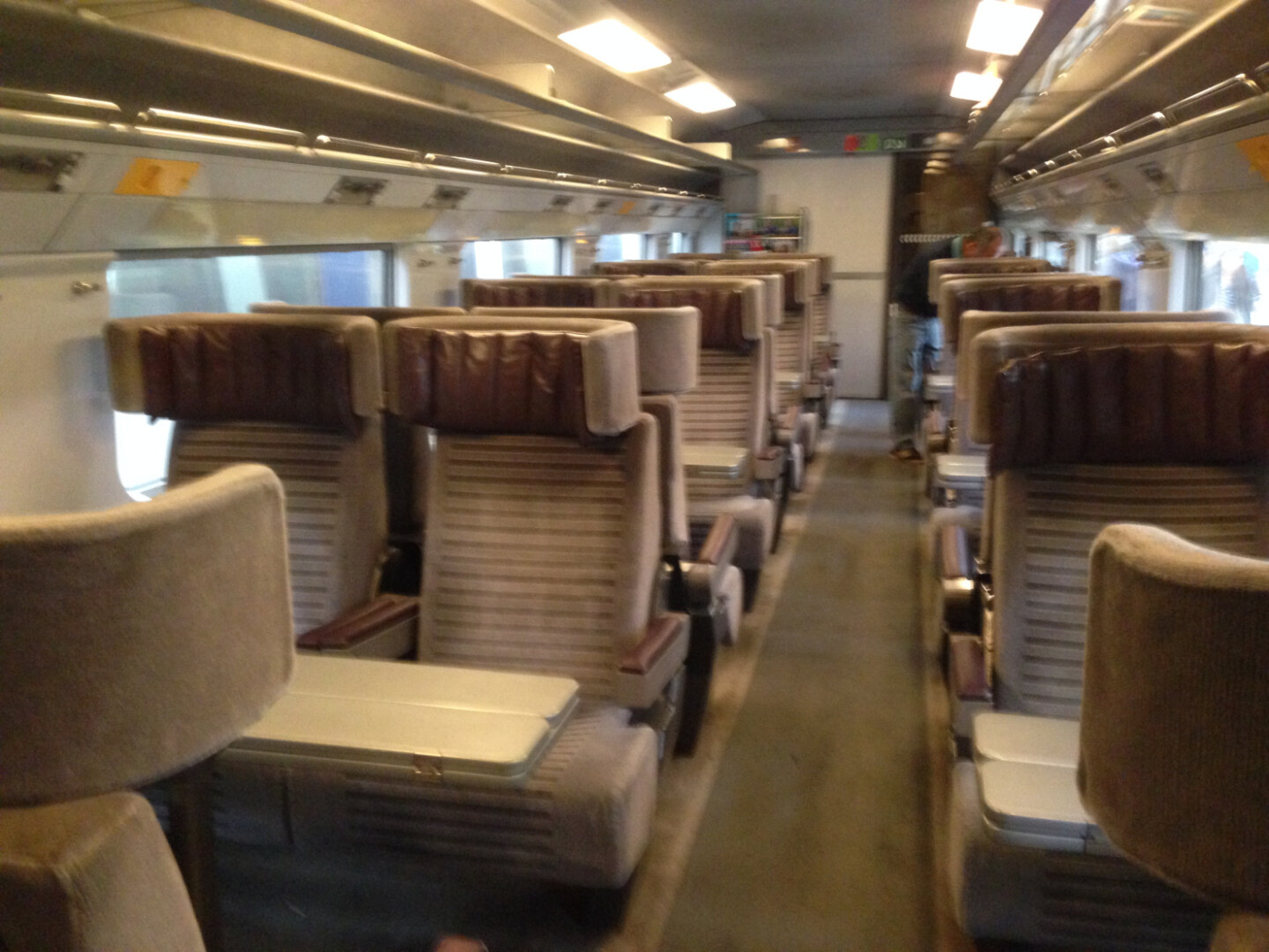 a train with seats and a person standing in the back